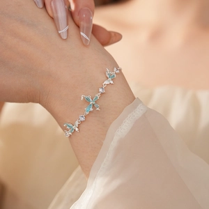Elegantes Armband mit blauem Schmetterling und Zirkonia am Handgelenk getragen