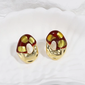 Close-up of French vintage burgundy resin earrings with abstract gold metallic finish