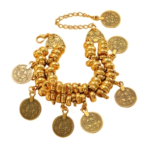 Detail van de gelaagde gouden boheemse armband met gegraveerde muntvormige hangers