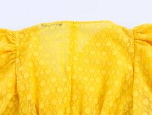 Detailaufnahme von gelbem Stoff mit rundem Jacquard und verdecktem Reißverschluss