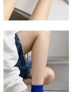 Dettaglio di calzini blu scuro abbinati a pantaloncini di jeans per un look casual