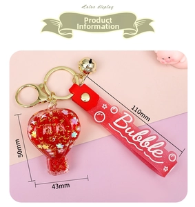 Detail of red hot air balloon keychain with gold sequins, bell and Bubble strap
