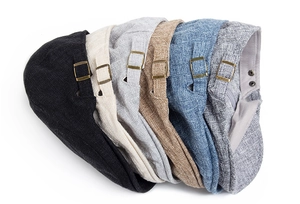 Close-up of adjustable metal side buckles on various cotton linen flat caps for men