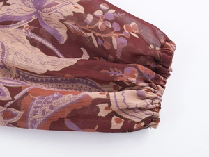 Detail of elastic cuff on bohemian paisley chiffon maxi dress with intricate floral pattern