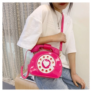Detail of creative rose pink telephone crossbody bag with vintage dial and handle strap