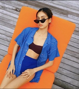 Close-up of klein blue bikini set and brown shirt on a wooden deck during a resort vacation