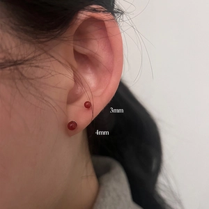 Model wearing 3mm and 4mm red agate stud earrings showing size comparison on ear