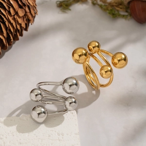 Goldene und silberne geometrische Spiralringe auf minimalistischem Steinhintergrund