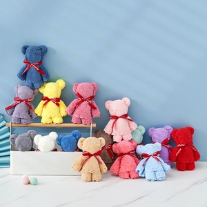 Colorful coral fleece teddy bear towels in a decorative basket for wedding party favors