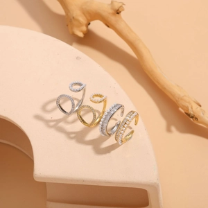 Detail view of 14K gold and silver rings with pearls and zircons on a beige stand