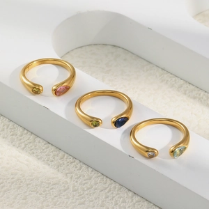 Detail of 18K gold snake head rings with colorful pear-cut zircons on white display