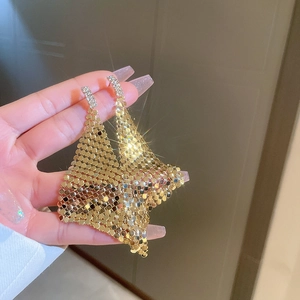 Close-up of gold tassel earrings with metallic sequins and sparkling rhinestones