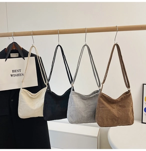 Corduroy tote bags in four colors hanging on a rack with adjustable straps and front pockets