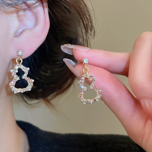 Close-up of gold gourd earrings with pavé pink crystals and pearls in a vintage style