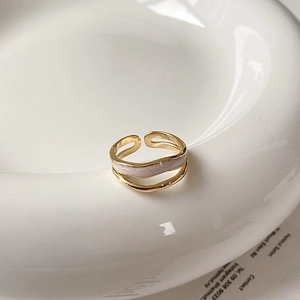 Vue détaillée d'une bague vague dorée ajustable avec incrustation de nacre blanche