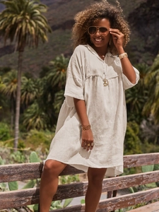 Detailed texture of white linen polo collar dress with buttons in natural light