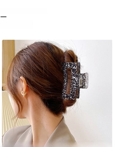 Détail d'une pince à cheveux léopard fixant une coiffure élégante sur cheveux longs