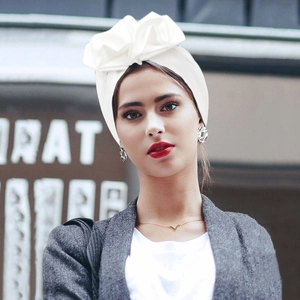 Detailed view of white pleated headwrap featuring a large satin bow knot for women