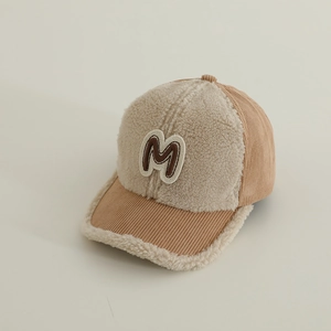 Detail of plush lamb wool and brown corduroy fabric textures on a warm baseball cap