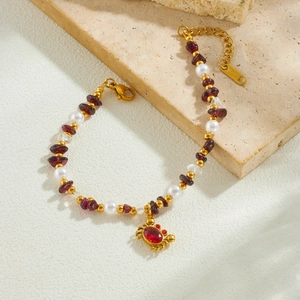 Bracelet en acier doré avec pierres rouges, perles et pendentif crabe élégant et chic