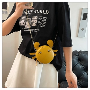 Detail of yellow crab shaped crossbody bag with gold chain strap on model