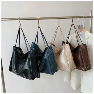 Detail showing four minimalist faux leather tote bags in black, blue, beige, and caramel