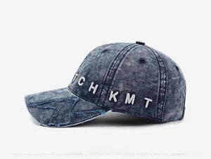 Close-up of vintage washed denim baseball cap with 3D letter embroidery and distressed brim
