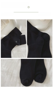 Detail of black knit socks showing high-elastic cuff with R embroidery and reinforced heel