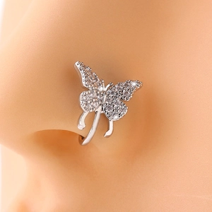 Macro shot of silver butterfly nose clip with clear rhinestones on model's nose