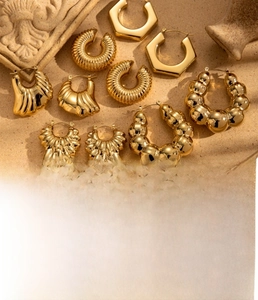 Detailed close-up of gold-plated titanium steel earrings with textured ripple and orb designs