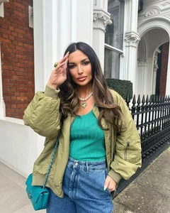 Streetstyle-Look mit olivgrüner Bomberjacke, grünem Top und blauer High-Waist-Jeans