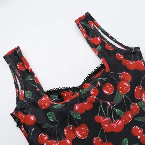 Detail of elegant cherry print dress with U-neckline and black lace trim decoration