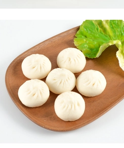 Top view of six realistic PVC steamed buns in a dark brown tray with green lettuce décor