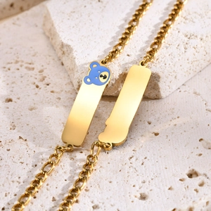 Gold tone stainless steel bracelet with blue enamel bear and dual rectangular plates
