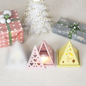 Detailed view of pyramid candle holders with festive snowflake and moon cutouts
