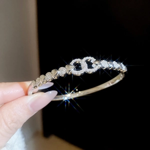 Macro detail of silver tone twisted bangle featuring crystal encrusted interlocking rings