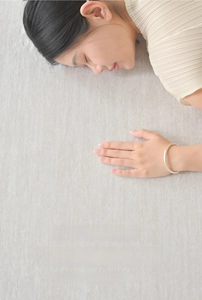 Detail of light grey eco-friendly rug featuring a soft knitted texture and skin-friendly feel