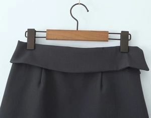 Detailopname van een donkergrijze rok met hoge taille en een omgeslagen tailleband