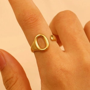 Macro detail of a gold adjustable oval ring showcasing its smooth polished metallic finish