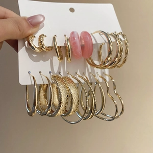 Close-up of resin and metal hoop earring set in gold, silver and pink on a white card