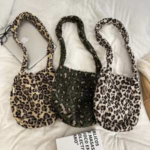 Detailed view of three leopard print faux shearling tote bags in various warm tones
