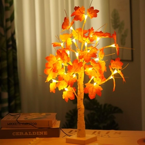 Detail of warm white LED maple leaf tree light on table for cozy autumn interior decor