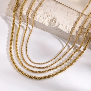 Gold-plated stainless steel twist rope chains in various thicknesses on a stone pedestal