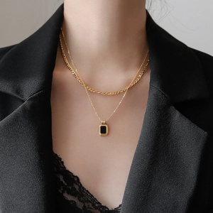 Close-up of double-layer titanium necklace with rectangular black pendant on model