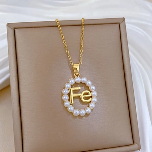 Elegant gold titanium necklace with a pearl-rimmed circular pendant featuring Fe letters