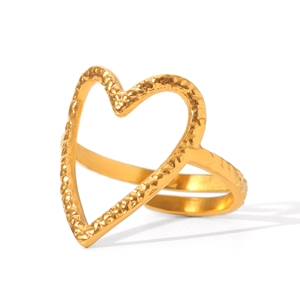 Detail of golden heart-shaped ring with hammered texture and smooth mirror finish