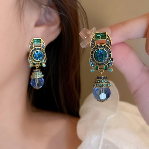 Vintage gold clip-on earrings with blue crystals and teardrop pendants for women