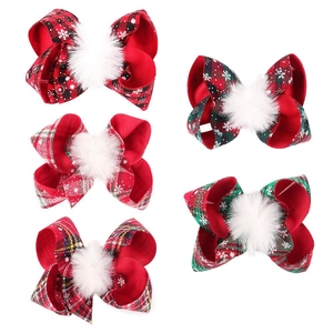 Detail of five festive Christmas hair bows with snowflake patterns and white pom-poms