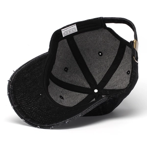Detail of denim baseball cap interior showing distressed brim and metal buckle strap