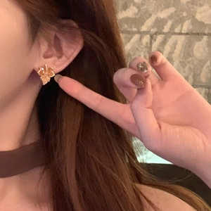 Exquisite 14k gold plated maple leaf stud earrings with shiny zircon on a model ear
